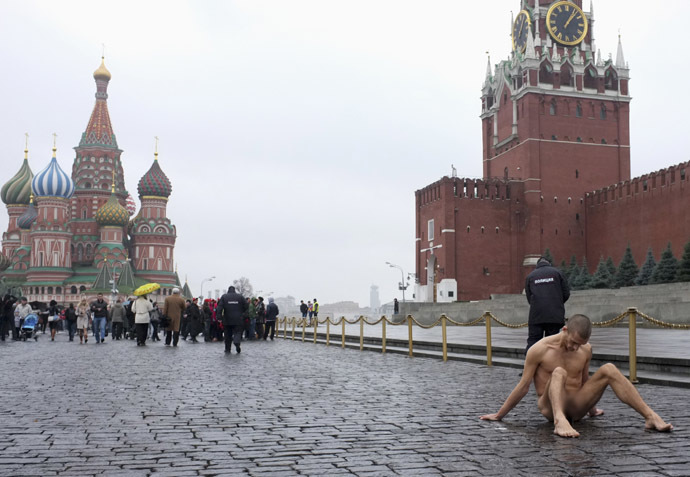 Pyotr Pavlensky sits on pavestones of Red Square during a protest action in front of the Kremlin wall in central Moscow