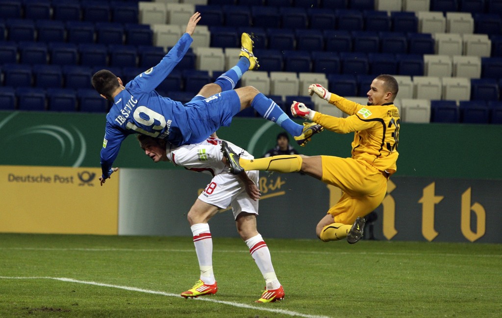 Hoffenheim's Ibisevic challenges Augsburg's Amsif and Callsen-Bracker during their German soccer cup match in Sinsheim
