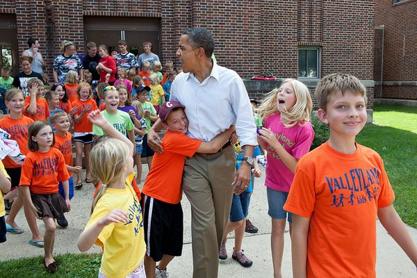 President Barack Obama greets children from the Valleyland Kids summer program outside a school in Chatfield, Minn., during a three-day bus tour in the Midwest, Aug. 15, 2011. (Official White House Photo by Pete Souza) This official White House photograph is being made available only for publication by news organizations and/or for personal use printing by the subject(s) of the photograph. The photograph may not be manipulated in any way and may not be used in commercial or political materials, advertisements, emails, products, promotions that in any way suggests approval or endorsement of the President, the First Family, or the White House.